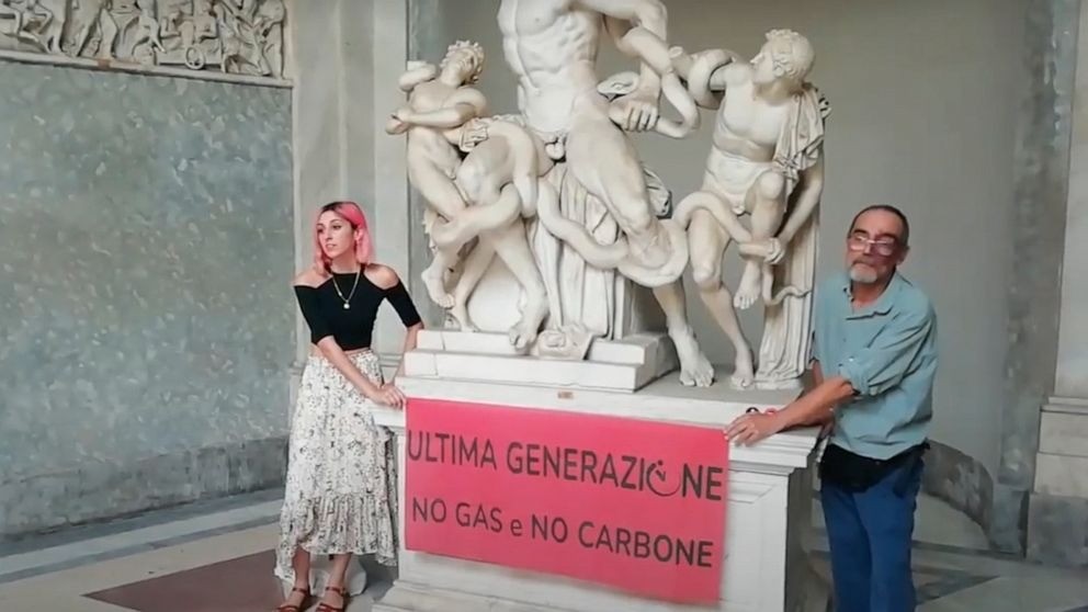 A video grab from a footage made available by environmental activists, shows two members of Ultima Generazione, or Last Generation in English, glued their hands on the Roman statue of Laocoön and His Sons, one of the masterpieces of the Vatican Museums collection, to protest against climate change, Thursday, Aug. 18, 2022. The activists displayed a banner reading, "Last Generation No Gas No Coal" urging politicians to listen to the call from the scientific community and act against climate change. (Ultima Generazione Via AP)