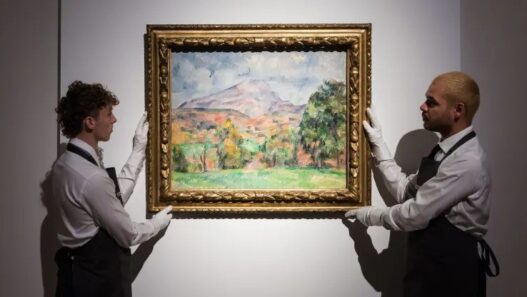 Art handlers hold a painting titled “La montagne Sainte-Victoire” by Paul Cezanne (estimate on request: in excess of $120,000,000) during a photo call to present the highlights from the estate of the philanthropist and co-founder of Microsoft, Paul G. Allen in London on Oct. 14, 2022.