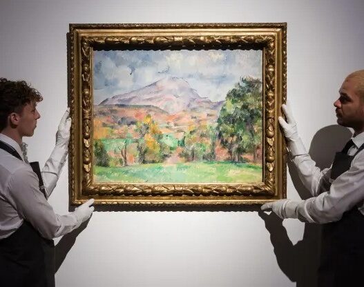 Art handlers hold a painting titled “La montagne Sainte-Victoire” by Paul Cezanne (estimate on request: in excess of $120,000,000) during a photo call to present the highlights from the estate of the philanthropist and co-founder of Microsoft, Paul G. Allen in London on Oct. 14, 2022.