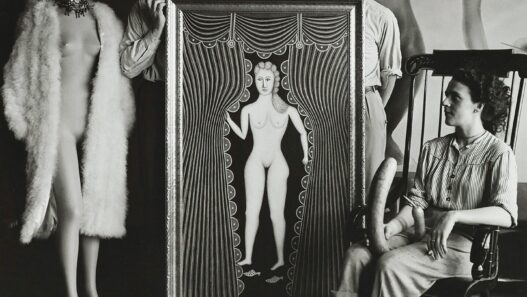 Hermann Landshoff, André Breton, Marcel Duchamp, Max Ernst [standing behind Morris Hirshfield’s Nude at the Window (Hot Night in July)], and Leonora Carrington (seated) at Peggy Guggenheim’s townhouse, Fall 1942, New York, NY. Digital print (original: gelatin silver print, 60 x 60 inches). © bpk. Digital image: bpk-Bildagentur/Münchner Stadtmuseum/Hermann Landshoff/Art Resource, New York.