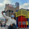 A selfie being taken in front of the cake model of a governmental building in Kahramanmaraş. The building, known as “the ugliest building in the World,” was demolished in 2022 due to its unattractive appearance. © DHA. Pavilion of Türkiye.